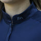 Nahaufnahme einer Person, die das Baselayer Short Sleeve – navy von EquiAttire mit EA-Strasssteinen am Kragen trägt.
