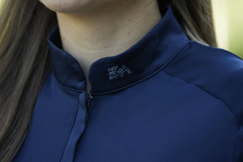 Nahaufnahme einer Person, die das Baselayer Short Sleeve – navy von EquiAttire mit EA-Strasssteinen am Kragen trägt.