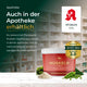 Ein Eimer Pferdegold Muskeln 2.0 Sojafrei zur Unterstützung der Pferdemuskulatur, der in einer Apotheke inmitten von Kräutern ausgestellt ist, mit einem Text, der die Verfügbarkeit des Produkts hervorhebt.