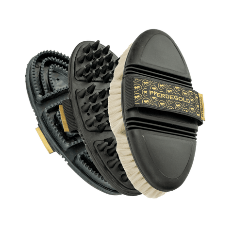 Drei Pferdegold® Putzbox Bürsten Set Bürsten gestapelt, die ihre unterschiedlichen Borsten- und Gummitexturen für die Pferdepflege hervorheben.